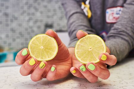 Halves of lemon and lime in female hands.の写真素材