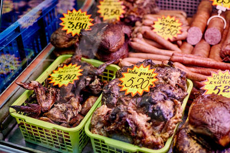 Riga, Latvia- February 06, 2020: Smoked meat products on the market counter.のeditorial素材