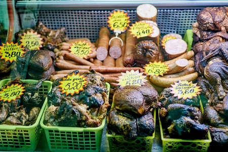 Riga, Latvia- February 06, 2020: Smoked meat products on the market counter.のeditorial素材