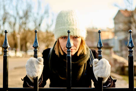 Woman traveler in a coat with a camera near a stone wall.の写真素材