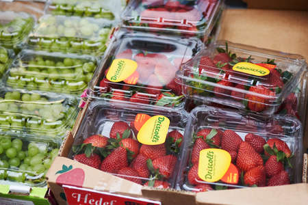 Vienna, Austria - March 10, 2020: Strawberries and grapes on the counter of a street shop in the city.のeditorial素材