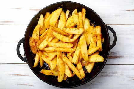 Cooking fried potatoes in a pan. Sliced potato with spices.の写真素材