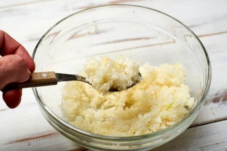 Finely chopped onions on a light wooden background.の写真素材