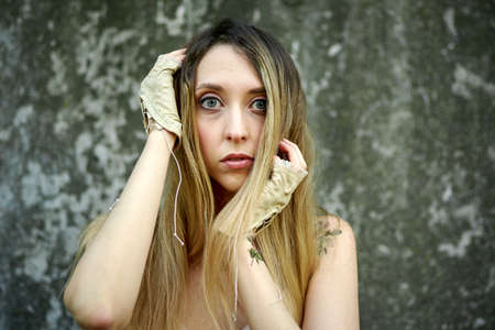 Kiev, Ukraine - June 07, 2020: Woman with long natural hair on a concrete wall background.のeditorial素材