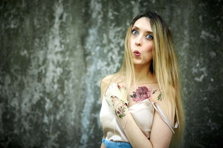 Kiev, Ukraine - June 07, 2020: Woman with long natural hair on a concrete wall background.