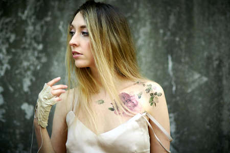 Kiev, Ukraine - June 07, 2020: Woman with long natural hair on a concrete wall background.のeditorial素材