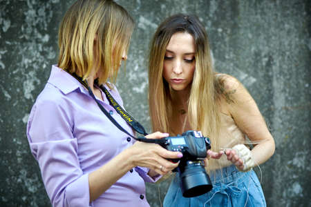 Kiev, Ukraine - June 07, 2020: A woman photographer takes pictures of a girl in the street