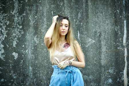 Kiev, Ukraine - June 07, 2020: Woman with long natural hair on a concrete wall background.のeditorial素材