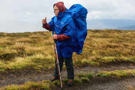 Carpathians, Ukraine- September 29, 2018: A man hiking in a raincoat during a hiking trip.