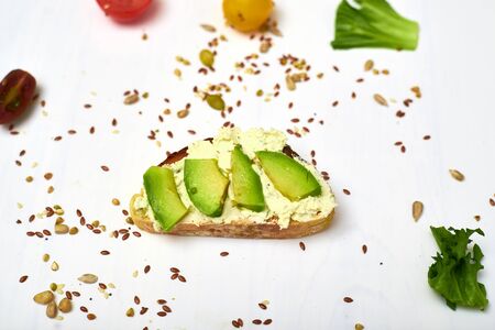 Ciabatta with cream cheese and avocado on a white background.
