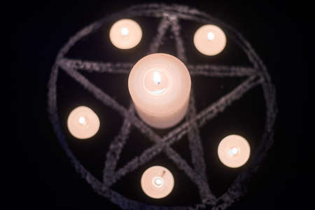 Pentagram and burning candles. The magical ritual of Satanism, invocation of spirits, spiritualistic sessions.の写真素材