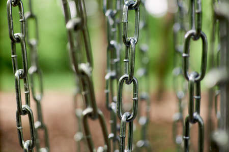 Metal chains are hanging. Abstract image, may be used as background.の写真素材