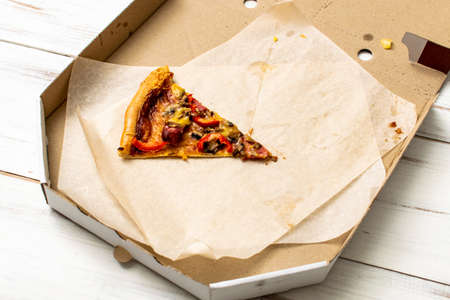 One last slice of pizza in a box.