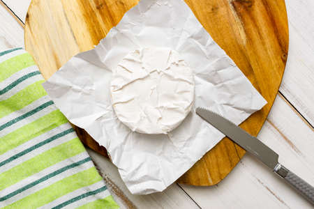 Round piece of camembert cheese on a wooden background.の写真素材