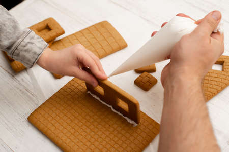 Dad and son are making a gingerbread house. Preparing for Christmas.