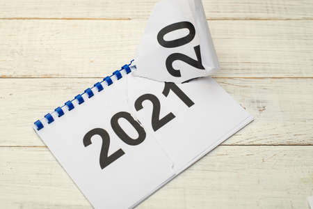 Coming new 2021 concept. Flipping over a notebook with inscriptions of years.