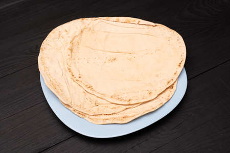 Round pita bread on a dark wooden background.の写真素材