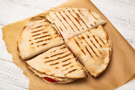 Pita, tortilla with cheese and ham on a white wooden background. A light, healthy snack.の写真素材