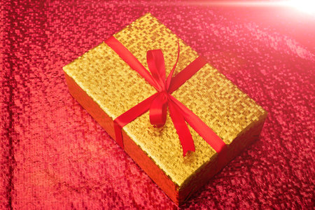 Gift in a gold package on a red background.