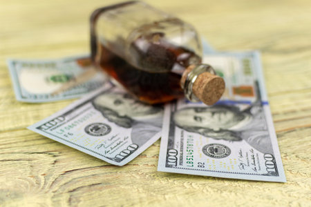 Hundred dollar bills on a wooden background and a bottle of elixir.の写真素材