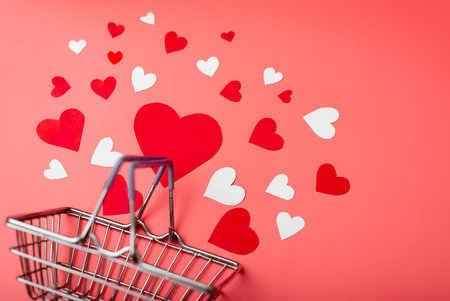 Shopping for valentine's day concept. Shopping basket and hearts on a red background.の写真素材