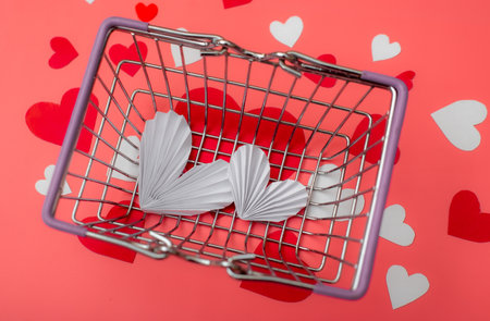 Shopping for valentine's day concept. Shopping basket and hearts on a red background.の写真素材