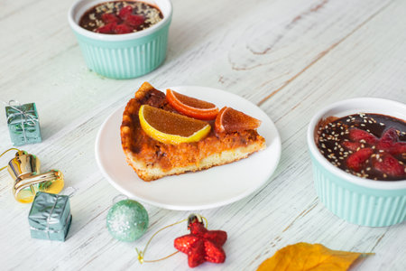 Piece of pumpkin pie on a white plate. Vegetarian baked goods, dessert.