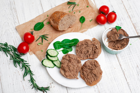 Sandwiches, canapes with chicken pate, tomatoes and cucumbers. On a white wooden background.の写真素材