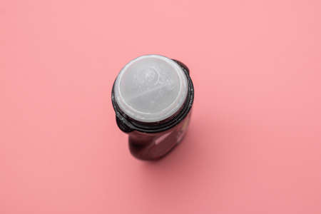 Roll-on deodorant on a pink background.