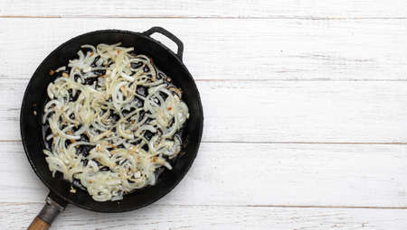 Fried onions in a pan. Cooking ingredient. Banner. Place for text.の写真素材