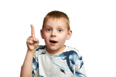 Portrait of a little boy excited with an idea. A boy holds his index finger up isolated on a white...