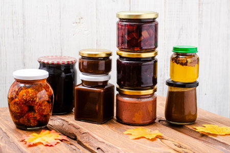 Various canned foods in jars on a light wooden background. Organic food.の写真素材