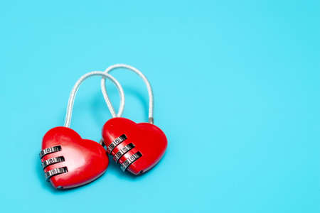 Two clasp hearts connected together on a blue background. The concept of love connection,...