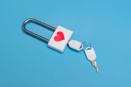 Lock with a heart and a key on a blue background.