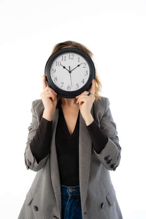 A woman holds a watch in front of her face. Isolated on white. Deadline, procrastination conceptの写真素材