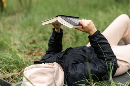 A woman lies on the grass and reads a book. Camping, relaxation.の写真素材
