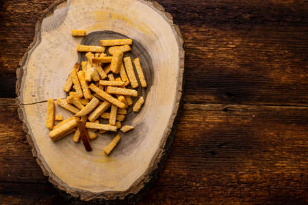 Wheat fried croutons on a wooden background. Snack on a platter made from a cut of wood.の写真素材