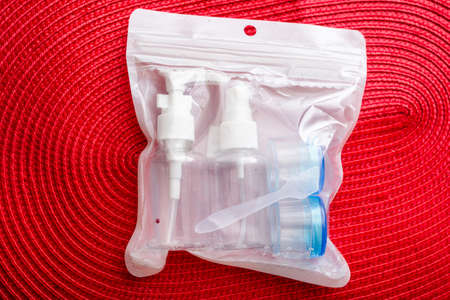 Set of plastic containers, containers for air travel on a red background.