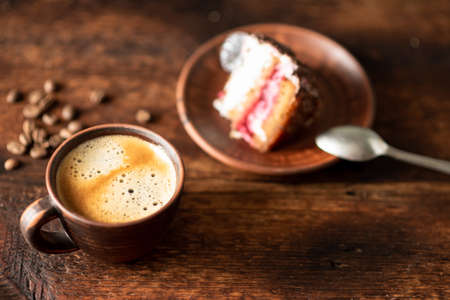 Cup of coffee and a piece of cake on a dark wooden background.の写真素材