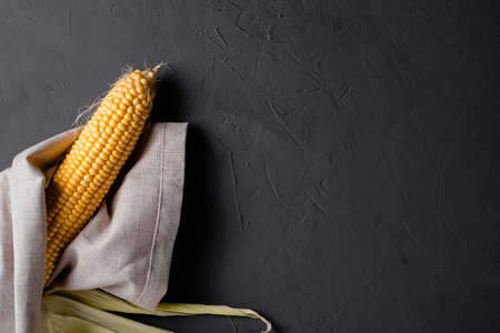 Peeled raw corn on a gray concrete background.の写真素材
