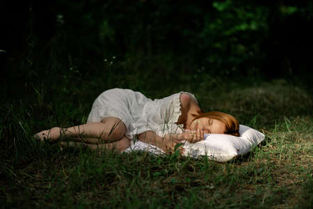 A woman sleeps in the woods on a pillow. Healthy, sound sleep concept. Rest, relaxation in nature.