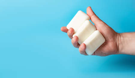 Global Handwashing Day. Bars of soap in a man's hand on a white background. Personal hygiene concept, hand washing. Banner, place for text.の写真素材