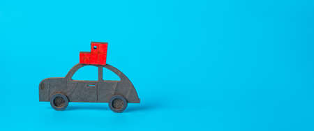 New year, christmas concept. Car with New Year's gifts on the roof on a blue background. Banner,...