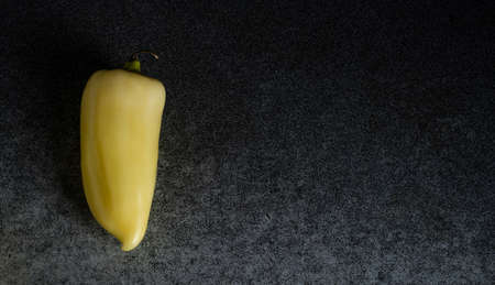 Fresh yellow peppers on a dark kitchen table. Place for your text.の写真素材