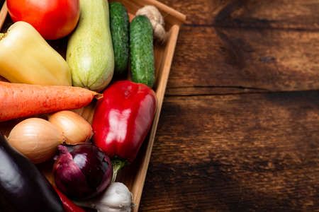 Various vegetables - zucchini, eggplant, pepper, tomato on a dark wooden background. Preparation for cooking.の写真素材