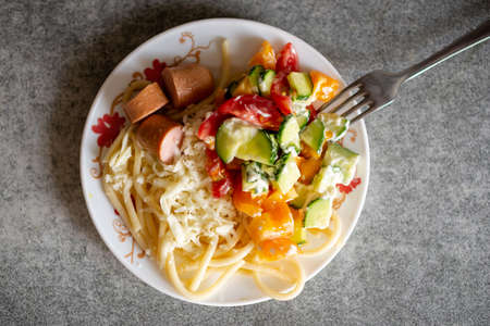 Homemade pasta with cheese and salad on a plate.の写真素材