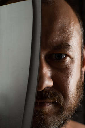Unshaven middle-aged man with a butcher knife close-up.の写真素材