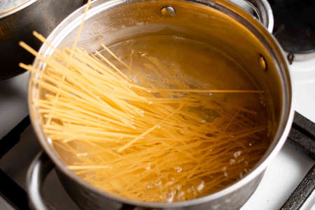 Spaghetti is boiled in water. Cooking Italian pasta at home.の写真素材