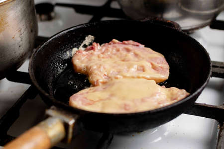 Meat chop in batter is fried in a pan. Cooking meat food.の写真素材