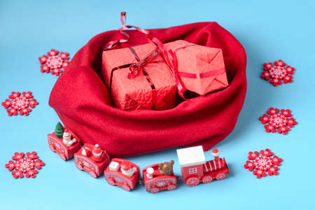 New Year gifts concept. Bag with wrapped gifts and New Year's steam locomotive on a blue background.の写真素材